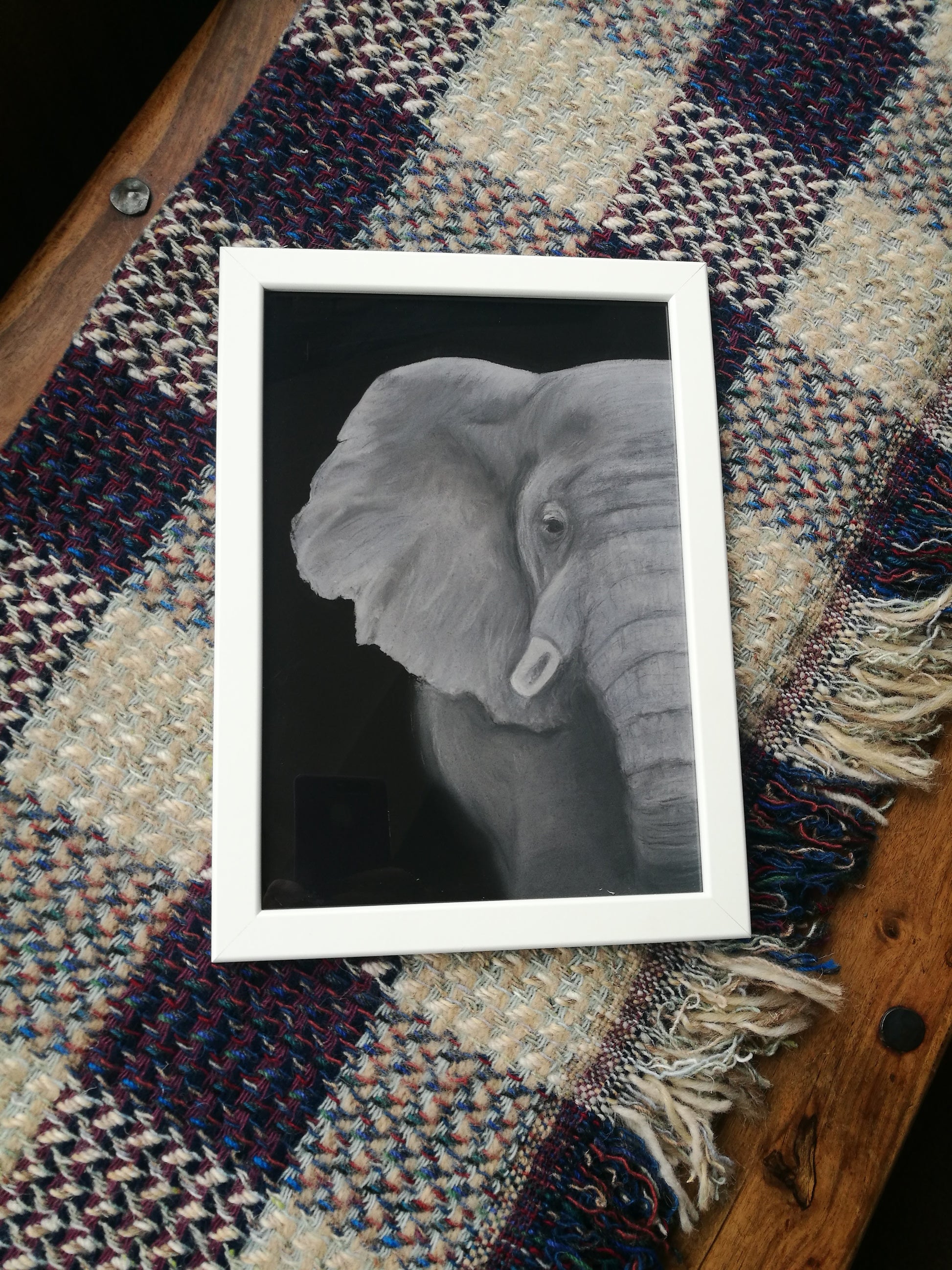 Grey and white pastel artwork of an African elephant on a black background - example in a white frame